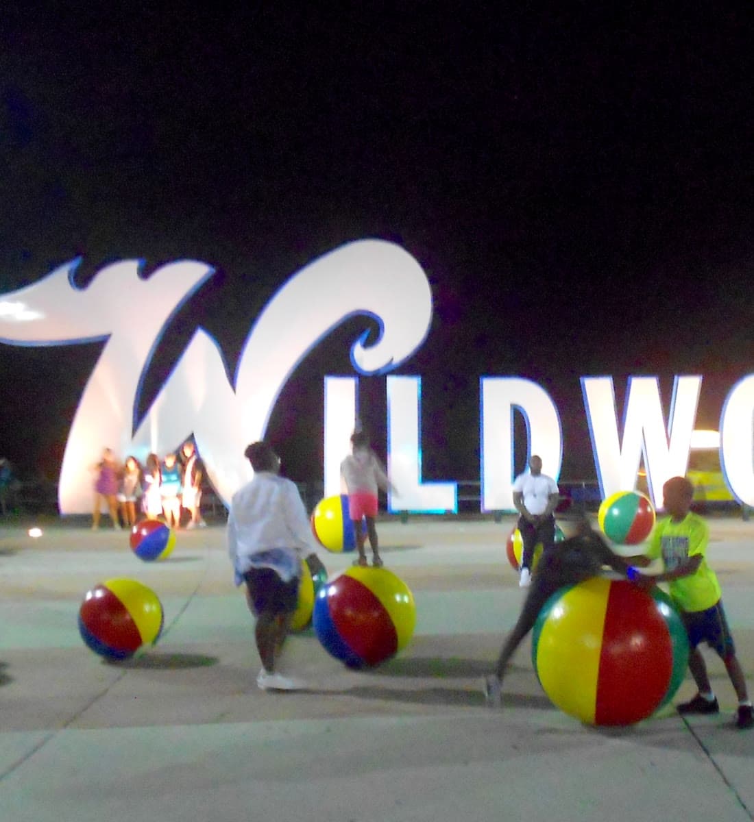 The giant Wildwoods sign glowing at night, with oversized beach balls in front